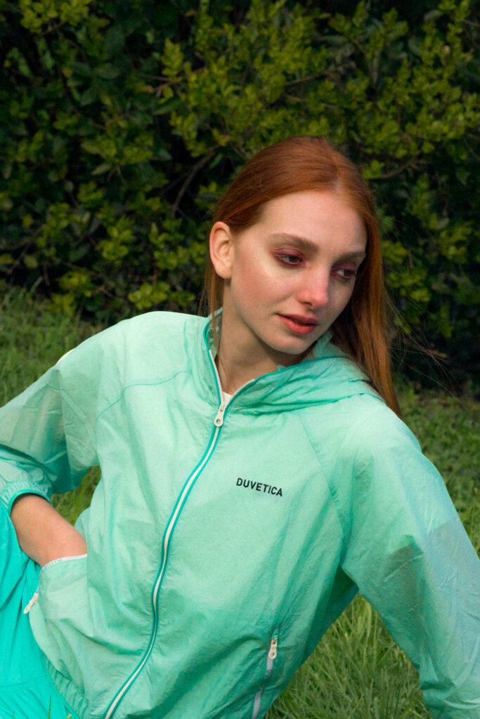 Modello femminile indossa giacca turquoise Duvetica nella collezione SS25, posa in un ambiente naturale, fotografia di Marius Cruceriu