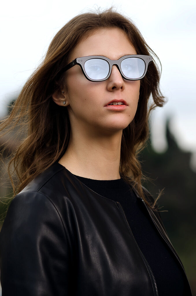 Modella indossa occhiali da vista artigianali con montatura nera, campagna moda eyewear fotografata da Marius Cruceriu