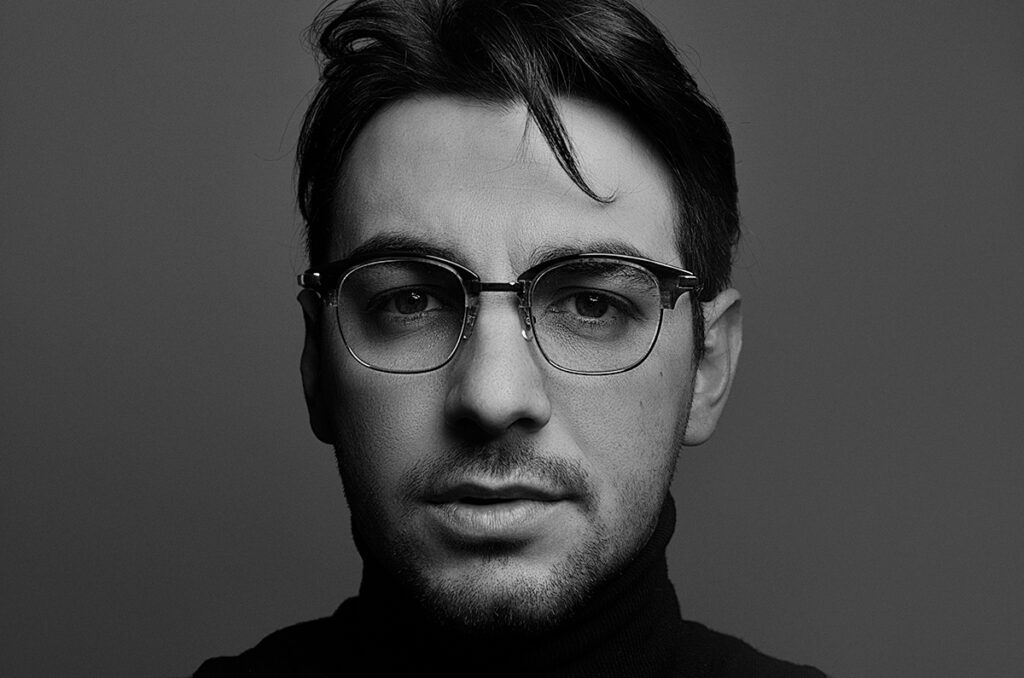 Ritratto in bianco e nero di uomo con occhiali da vista artigianali, fotografato da Marius Cruceriu