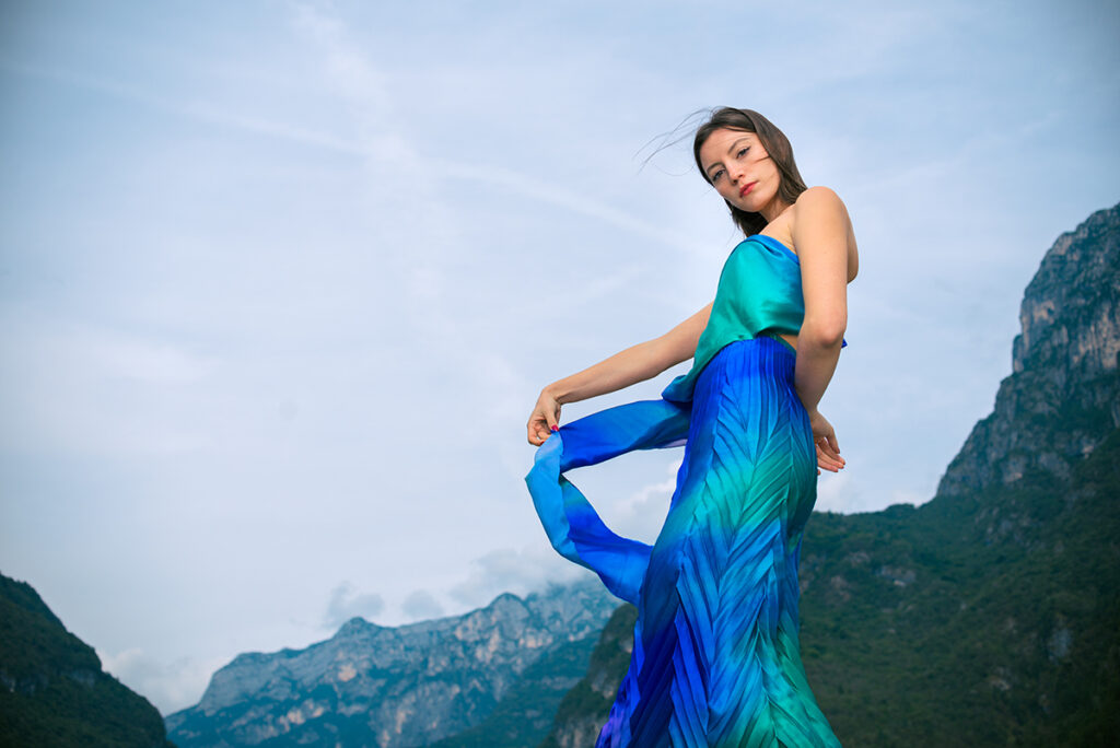 Modella con abito colorato in seta firmato Mine de Rien Couture fotografata in montagna, campagna moda “Symbiosis” di Marius Cruceriu.