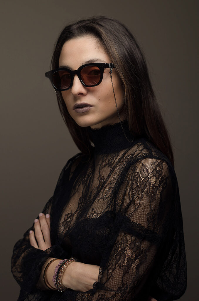 Ritratto moda con occhiali da sole artigianali indossati da donna in pizzo nero, fotografia elegante e raffinata
