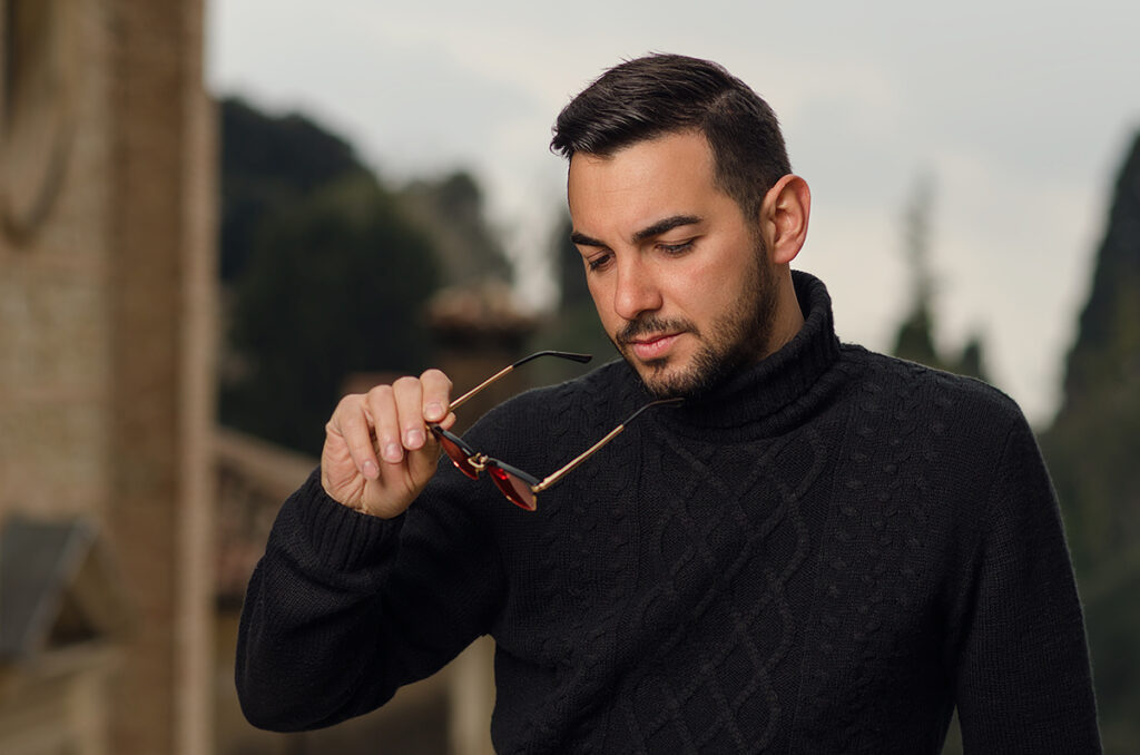 Ritratto maschile con occhiali da sole in mano, scatto moda per un brand eyewear italiano artigianale, foto di Marius Cruceriu