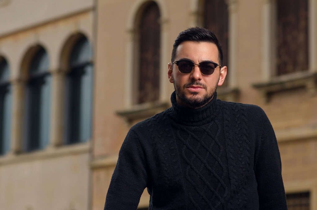 Uomo indossa occhiali da sole artigianali in città italiana, ritratto moda casual elegante