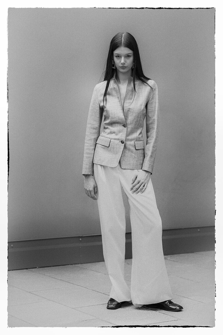 Modella Zuzanna in full figure durante un test per Supreme Management Milano, in posa frontale con blazer chiaro e pantaloni ampi bianchi, fotografata da Marius Cruceriu in bianco e nero.