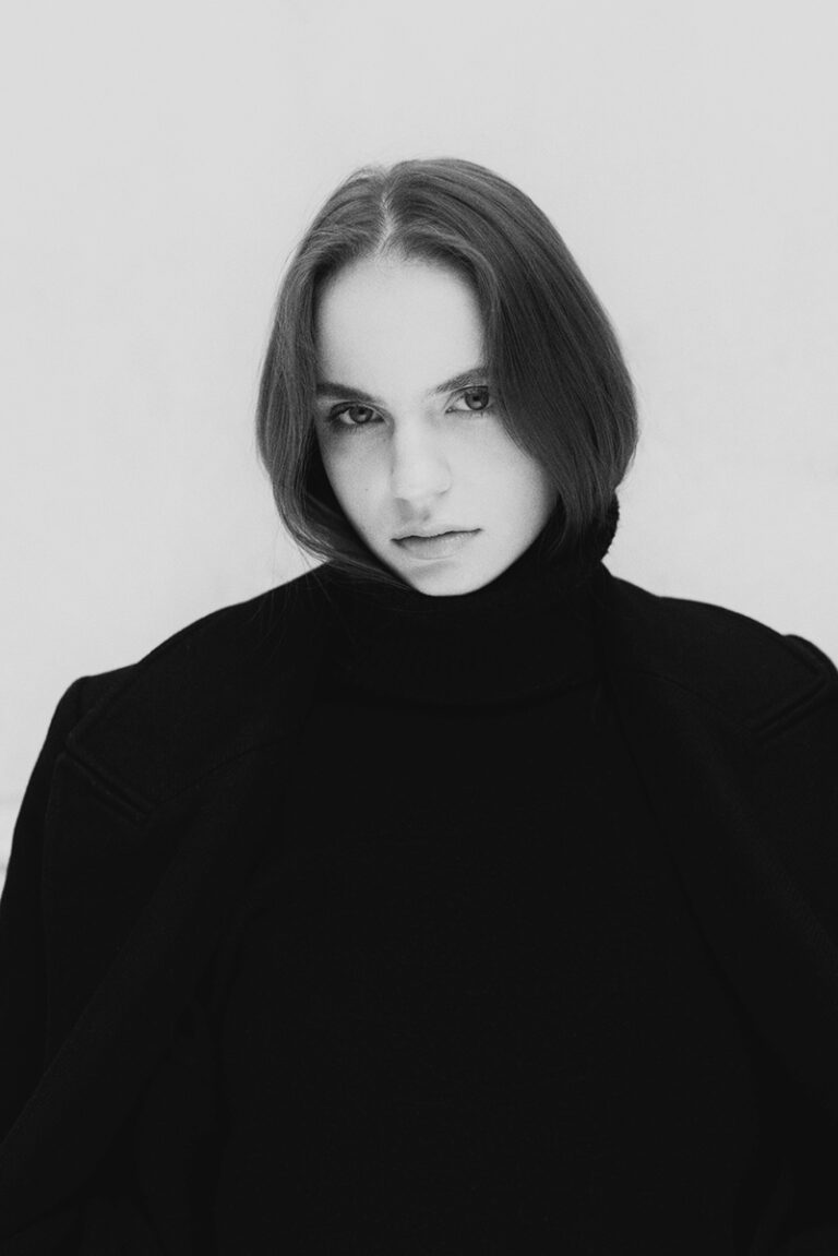 Modella Liddy per Novastars Models, intenso ritratto in bianco e nero con dolcevita nero, sguardo magnetico in camera, test model realizzato da Marius Cruceriu.