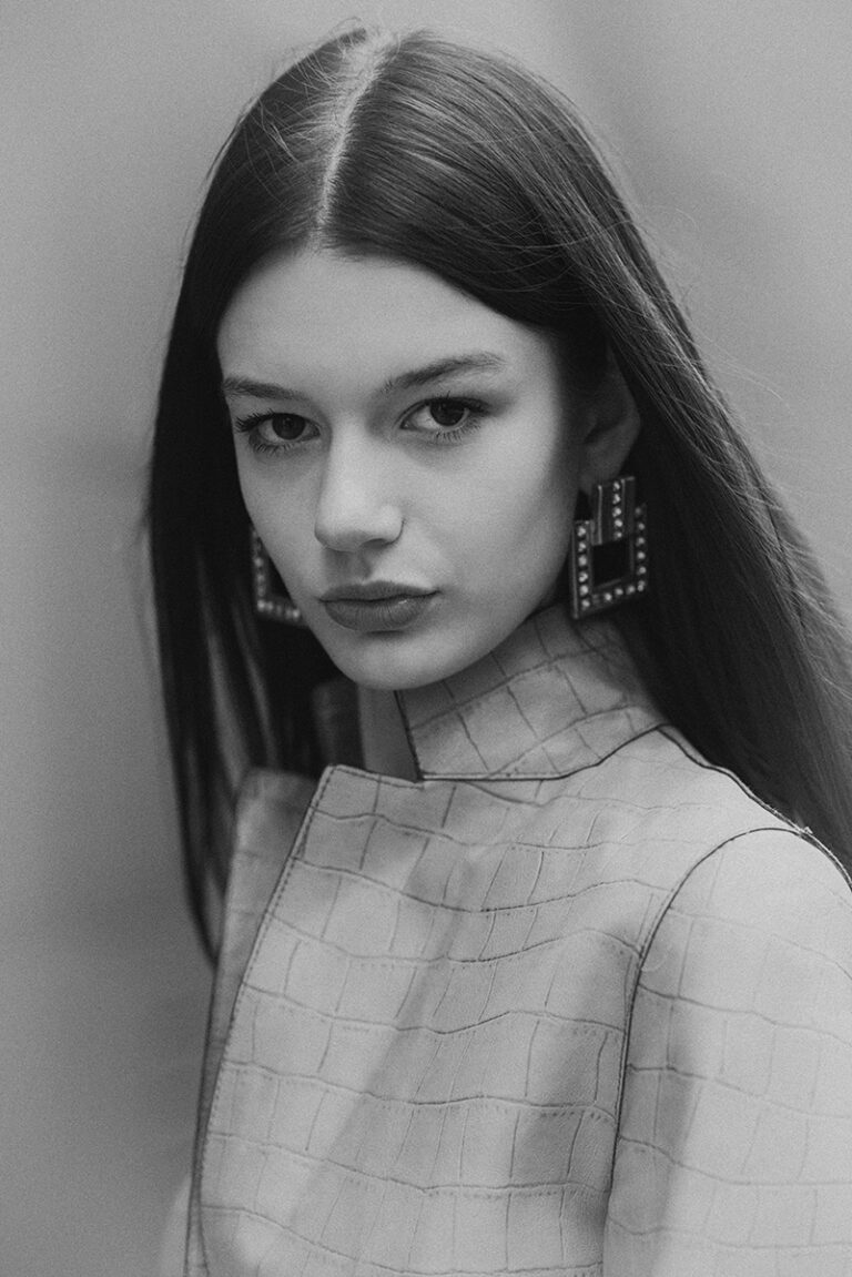Ritratto in bianco e nero della modella Zuzanna durante un test per Supreme Management Milano, con capelli lisci lunghi e giacca chiara texture coccodrillo, fotografata da Marius Cruceriu.